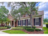 Charming two-story home featuring a cozy front porch, manicured landscaping and decorative shutters at 10309 Marchmont Ct, Tampa, FL 33626