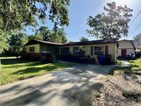 Charming single-story home with mature trees, a long driveway, and lush landscaping at 1703 N Taylor Rd, Brandon, FL 33510