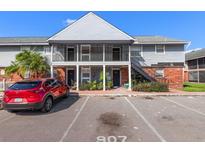 Charming two-story condo building with gray siding, brick accents, and convenient parking available at 200 Country Club Dr # 906, Largo, FL 33771