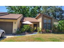 Inviting single-story home with a well-manicured lawn, garden, and neutral-colored brick facade at 2101 Sunset Point Rd # 2305, Clearwater, FL 33765