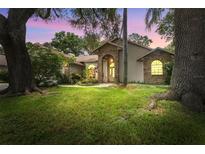 Charming single-story home featuring a brick archway, lush lawn, and mature trees at 3001 Folklore Dr, Valrico, FL 33596