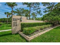 Well-maintained community sign surrounded by lush landscaping and mature trees at 3062 Eastland Blvd # 402, Clearwater, FL 33761