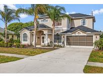 Stunning two-story home features lush landscaping, an attached two-car garage, and a well-maintained driveway at 3434 St Ives Blvd, Spring Hill, FL 34609