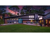 Charming, mid-century home with a modern gray exterior, lush lawn, and eye-catching landscaping at 4610 Cypress S Way, St Petersburg, FL 33705