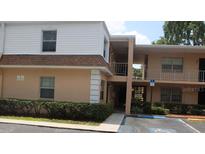 Two-story condo featuring neutral paint, brown roof, manicured bushes and accessible parking at 4725 Joseph Ct # 233, Tampa, FL 33614