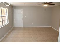 A bright living room features neutral walls, tile flooring, and a ceiling fan at 4725 Joseph Ct # 233, Tampa, FL 33614
