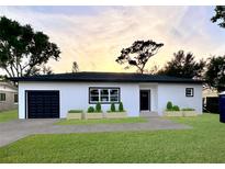 Charming single-story home boasting fresh white paint, black accents, an attached garage, and green lawn at 4920 72Nd N St, St Petersburg, FL 33709