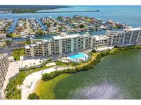 Expansive aerial view of condo complex with a pool, beach, and waterfront access on a sunny day at 6009 Sea Ranch Dr # 107E, Hudson, FL 34667