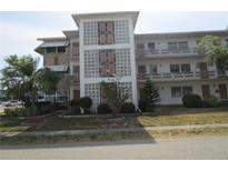 Attractive three-story condo building featuring decorative concrete block, balconies, and professional landscaping at 6015 19Th N St # 301, St Petersburg, FL 33714