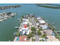 Stunning aerial view of waterfront home with lush landscaping, private pool, and solar panels at 860 Harbor Is, Clearwater Beach, FL 33767