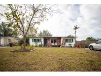 Charming single-story home with well-maintained lawn, brick accents, and cozy front porch sitting area at 8742 Narcissus Ave, Seminole, FL 33777