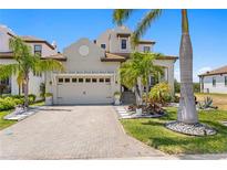 Beautiful home with a two-car garage, manicured landscaping, and a brick driveway at 916 Seagrape Dr, Ruskin, FL 33570
