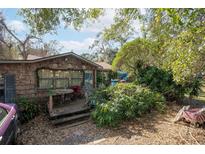 Charming house with a covered porch surrounded by lush landscaping, creating a cozy entrance at 9810 Parsons St, Tampa, FL 33615