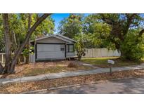Charming single-story home with light-colored siding, surrounded by mature trees and a well-manicured lawn at 1007 Jones St, Clearwater, FL 33755