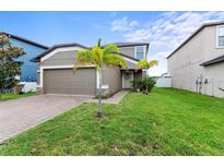 Charming single-Gathering home showcasing a well-maintained lawn and a cozy front entrance with beautiful landscaping at 11871 Crestridge Loop, Trinity, FL 34655