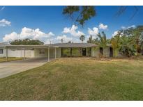 Charming single-story home with a well-maintained lawn and a convenient carport at 1450 Palmetto St, Clearwater, FL 33755