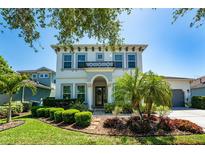 Stately two-story home with a beautifully landscaped front yard, mature trees, and a charming balcony at 15422 Starling Crossing Dr, Lithia, FL 33547