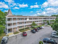 Spacious condominium complex featuring a beige exterior, ample parking, and lush landscaping in a vibrant community at 2436 Rhodesian Dr # 24, Clearwater, FL 33763