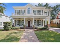 Charming two-story home with a welcoming front porch, balcony, and lush landscaping at 2714 W Jetton Ave, Tampa, FL 33629
