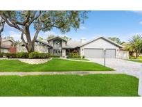 Charming single-story home with stone accents, a well-manicured lawn, and an attached two-car garage at 3342 Waterford Dr, Clearwater, FL 33761