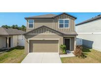 Charming two-story home featuring a two-car garage, well-maintained lawn, and attractive modern architecture at 34847 Daisy Meadow Loop, Zephyrhills, FL 33541