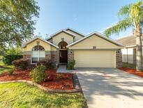 Charming home with stone accents, lush landscaping, and a well-manicured lawn at 441 Thicket Crest Rd, Seffner, FL 33584