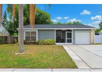 Charming single-story home with mature landscaping, screened porch, and attached one car garage at 5708 Ridgestone Dr, Tampa, FL 33625
