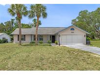 Charming single-story home with well-manicured lawn and a two-car garage at 7337 Glasgow Rd, Weeki Wachee, FL 34613