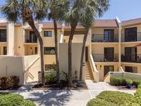 Beautiful condo exterior featuring palm trees, balconies, and tropical landscaping at 7500 Sunshine Skyway S Ln # 201, St Petersburg, FL 33711