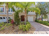 Inviting townhouse with meticulous landscaping, front lawn and paver driveway at 800 Callista Cay Loop, Tarpon Springs, FL 34689