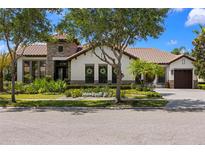 Beautiful single-story home with lush landscaping, stone accents, and a well-manicured lawn at 8434 Dunham Station Dr, Tampa, FL 33647