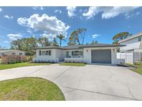 Charming single-story home with a well-manicured lawn and a spacious concrete driveway at 110 8Th St, Belleair Beach, FL 33786