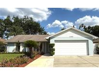 Charming single-story home with a two-car garage, brick accents, and well-maintained landscaping at 11303 Hollyglen Dr, Tampa, FL 33624