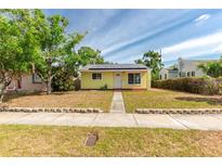 Charming yellow home featuring solar panels and a well-maintained front yard at 4517 2Nd S Ave, St Petersburg, FL 33711