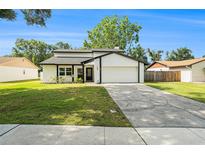 Inviting two-story home featuring a well-manicured lawn and an attached two-car garage at 4914 Country Hills Dr, Tampa, FL 33624