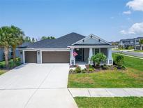 Charming single-story home featuring a well-manicured lawn, a three-car garage, and an inviting front porch at 5828 Clairwood Ct, Palmetto, FL 34221