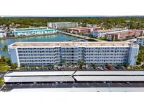 Exterior of building with parking lot and covered parking and view of other community buildings in the background at 5925 Shore S Blvd # 602, Gulfport, FL 33707