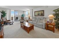 Bright living room with comfortable seating and balcony access showcasing water views at 7665 Sun Island S Dr # 307, South Pasadena, FL 33707