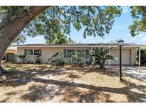 Charming single-story home featuring mature trees, inviting landscaping, and neutral exterior paint at 8696 118Th St, Seminole, FL 33772