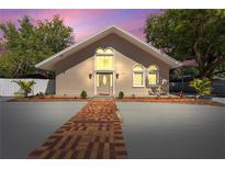 Charming home with a well-manicured lawn, brick path and delightful architectural details at 11709 N Armenia Ave, Tampa, FL 33612
