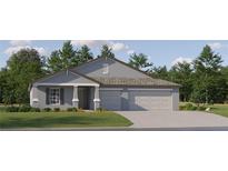 Beautiful single-story home featuring a three-car garage, manicured lawn, and classic architectural details at 13167 Violet Flame Ave, Wimauma, FL 33598