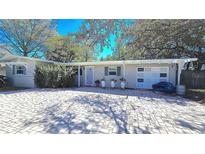 Charming single-story home featuring a spacious brick driveway and a well-manicured landscaped yard at 1755 Sunset Point Rd, Clearwater, FL 33755