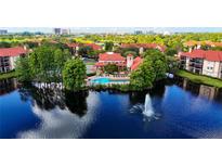 Stunning aerial view of a community waterfront pool with a fountain on the lake and red tiled roofs at 2400 Feather Sound Dr # 635, Clearwater, FL 33762