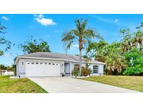 Charming single-story home featuring a lush, landscaped front yard and a two-car garage at 2675 Cherokee St, North Port, FL 34286