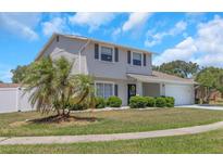 Charming two-story home features a well-manicured lawn, complemented by a blue door and a two-car garage at 3035 Annadale, Brandon, FL 33511