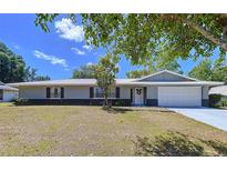 Charming single-story home with a well-manicured lawn and metal roof, perfect for curb appeal at 30456 Willow Bank Ave, Brooksville, FL 34602