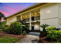 Inviting exterior view of a two-story condo building featuring well-maintained landscaping and open-air staircases at 4946 Mill Pond Rd # 3180, Wesley Chapel, FL 33543