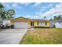 Charming single-story home with a front yard, white garage door, and classic design at 5920 Denver Ne St, St Petersburg, FL 33703