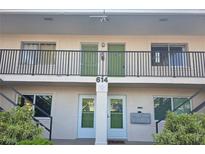 Two-story condo building featuring well-maintained landscaping and a secure entrance at 614 Guild Dr # 15, Venice, FL 34285