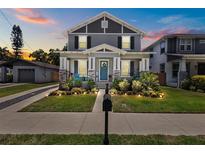 Charming two-story home with landscaped yard, cozy front porch and blue door at 710 W River Heights Ave, Tampa, FL 33603